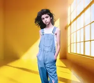Image d'une jeune fille assise dans un loft spacieux au style industriel, mettant en valeur des lignes graphiques et une lumière naturelle diffuse.