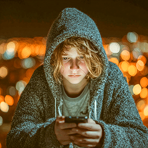 adolescent perplexe devant son smartphone